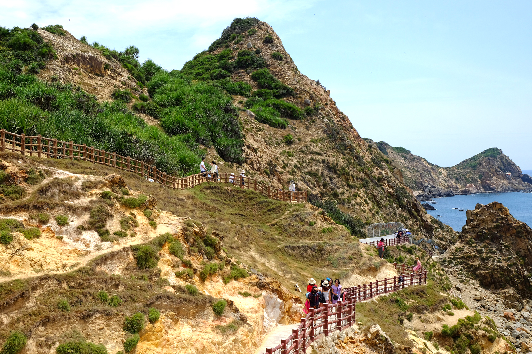 Du khách tham quan những con đường đi bộ uốn lượn theo sườn núi ở Eo Gió giữa tháng 6/2020.